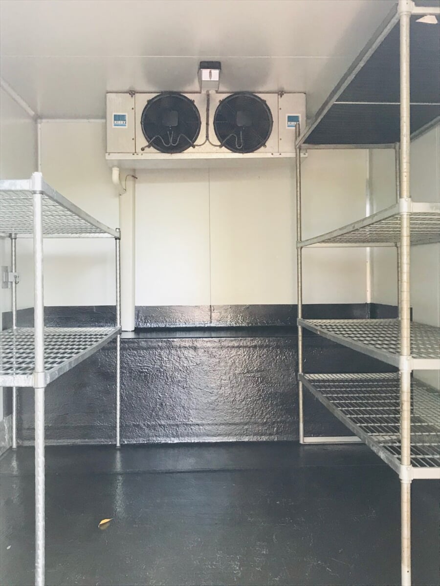Inside a mobile coolroom showing twin cooling fans and galvanised wire shelving